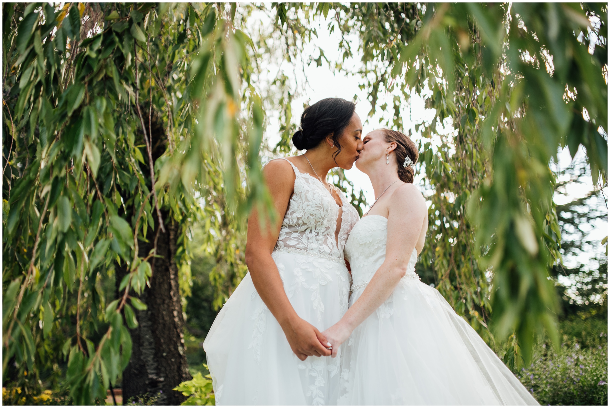 Two brides sharing an intimate portrait at New England Botanic Garden at Tower Hill during their same sex wedding