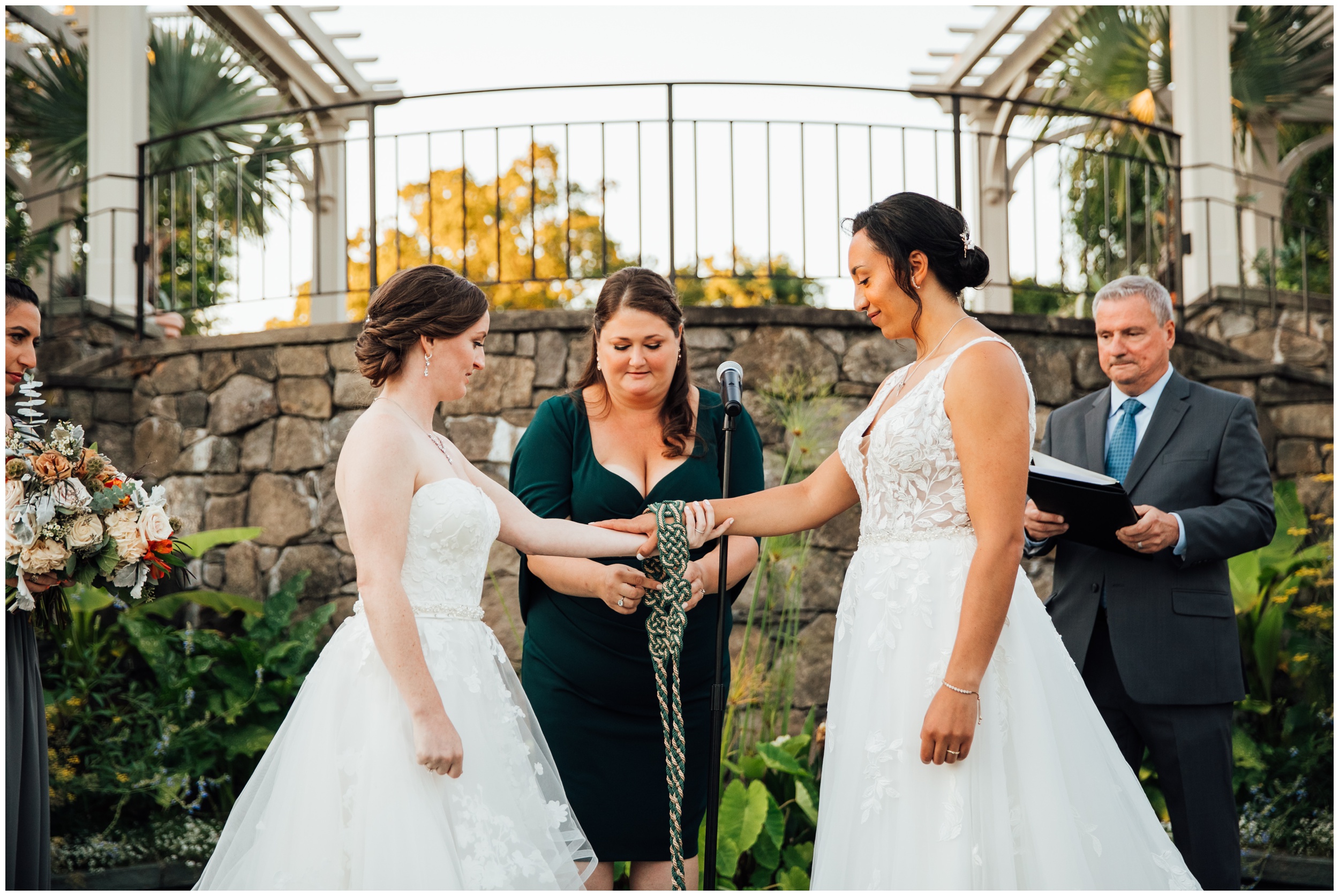 Two brides during handfasting ceremony at New England Botanic Garden at Tower Hill in Massachusetts