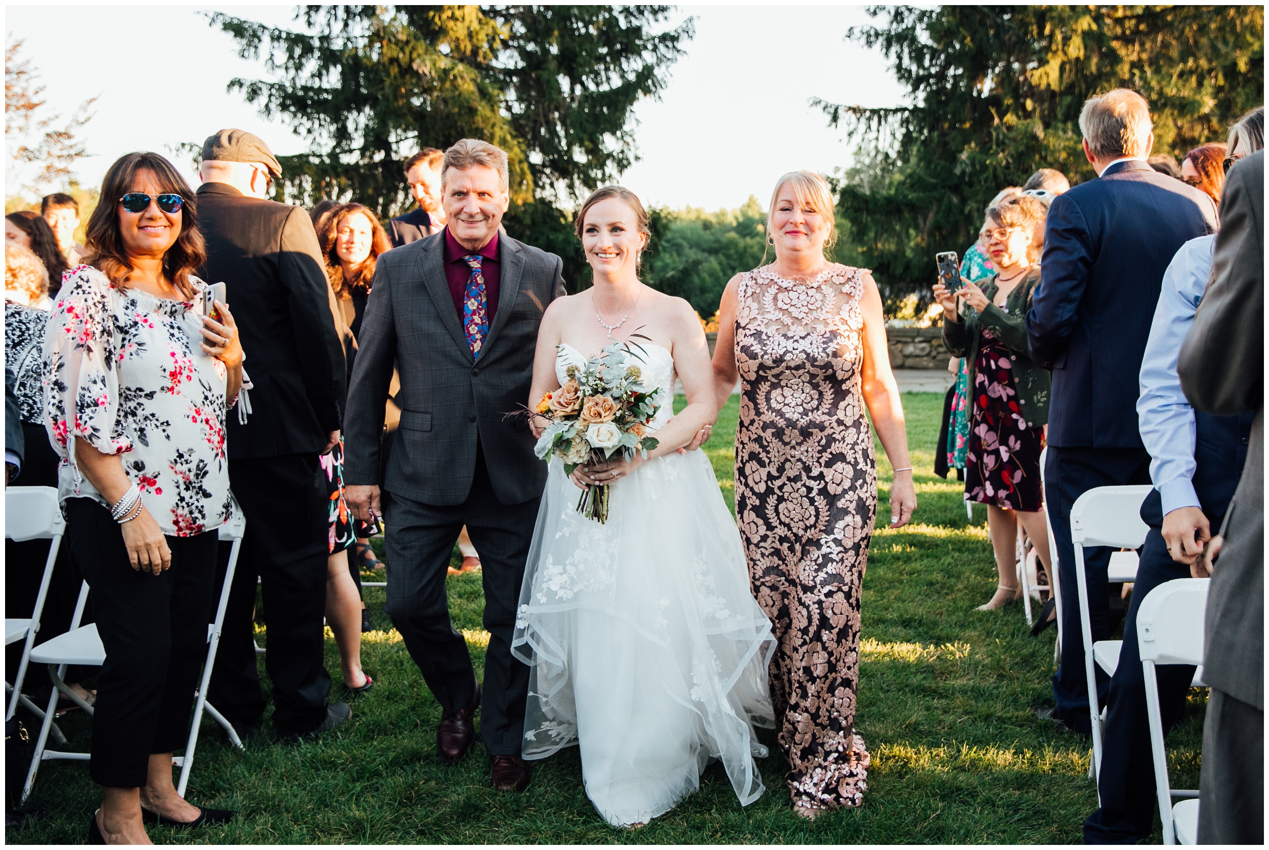 Brides walking down the aisle during outdoor ceremony at New England Botanic Garden at Tower Hill in Massachusetts